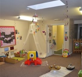 Baby room in Little Fingers Day Nursery is decorated in calming colours, and babies' artwork is displayed on the walls